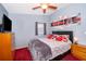 Bedroom boasts a modern aesthetic with stylish red and gray accents, alongside a ceiling fan and artwork at 3049 Condel Drive, Orlando, FL 32812