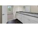 Bathroom features dual sinks with granite counters, tile floors, and access to bedroom at 31830 Sybil Ave, Sorrento, FL 32776