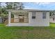 Side angle of the home's exterior featuring a covered porch, wood railing, and lawn at 31830 Sybil Ave, Sorrento, FL 32776