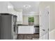 Stylish kitchen with granite countertops, stainless steel appliances, and sleek white cabinetry at 31830 Sybil Ave, Sorrento, FL 32776