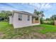 The home's backyard shows green grass, an enclosed porch and a peek into the side yard at 31836 Sybil Ave, Sorrento, FL 32776