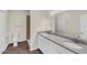 This bathroom boasts double vanities with granite countertops, a modern shower, and tile flooring at 31836 Sybil Ave, Sorrento, FL 32776