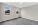 Bright bedroom with carpeted floors, two windows for natural light, and neutral colored walls at 31836 Sybil Ave, Sorrento, FL 32776