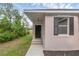 Close-up view of the front door with a modern light fixture and fresh landscaping at 31836 Sybil Ave, Sorrento, FL 32776