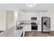 Modern kitchen featuring white cabinets, stainless steel appliances, and granite countertops at 31836 Sybil Ave, Sorrento, FL 32776