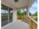 Covered patio with wooden railings and a sliding glass door overlooks a lush outdoor space at 31836 Sybil Ave, Sorrento, FL 32776