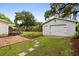 Backyard featuring a detached garage, brick patio, well-manicured lawn, and mature landscaping at 40 W Smith St, Winter Garden, FL 34787