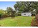 Backyard with a trellis and detached garage with mature trees, offering a peaceful and private outdoor setting at 40 W Smith St, Winter Garden, FL 34787