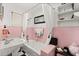 Retro pink and white tiled bathroom with a vintage sink, bathtub, shower, and black and white checkerboard flooring at 40 W Smith St, Winter Garden, FL 34787