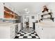 Galley kitchen featuring checkerboard floors, white cabinetry, and stainless steel appliances at 40 W Smith St, Winter Garden, FL 34787
