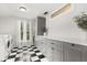 Well-lit laundry room with black and white checkerboard floor, and updated countertops and cabinets at 40 W Smith St, Winter Garden, FL 34787