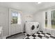 Laundry room with a full sized washer and dryer and black and white checkerboard floors near the back door at 40 W Smith St, Winter Garden, FL 34787