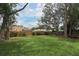Large backyard with a well-maintained lawn, mature trees, and a wooden fence, offering privacy and tranquility at 4201 Old Trafford Way, Orlando, FL 32810