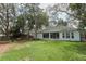 Spacious backyard with lush green grass, mature trees, and a screened patio, ideal for outdoor activities at 4201 Old Trafford Way, Orlando, FL 32810