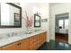 Bathroom boasts double sinks, framed mirrors, wood cabinets, and access to Primary bedroom at 4201 Old Trafford Way, Orlando, FL 32810