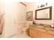 Bathroom features a marble vanity top, framed mirror, toilet, and decorative art at 4201 Old Trafford Way, Orlando, FL 32810