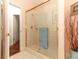 Bathroom shower enclosed by clear glass with gold frame, and white tile at 4201 Old Trafford Way, Orlando, FL 32810