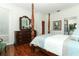 Bright bedroom with wooden four-poster bed, wooden dresser and view to connected bathroom at 4201 Old Trafford Way, Orlando, FL 32810