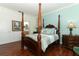 Charming bedroom showcases wooden four-poster bed with blue accents, and elegant furnishings at 4201 Old Trafford Way, Orlando, FL 32810