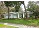 Charming light blue single-story home featuring a well-manicured lawn and mature trees at 4201 Old Trafford Way, Orlando, FL 32810