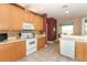 Eat-in kitchen featuring wood cabinets, modern appliances, and open view to dining area at 4201 Old Trafford Way, Orlando, FL 32810