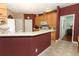 Kitchen with light wood cabinets, tiled floors and countertops, and view into hallway at 4201 Old Trafford Way, Orlando, FL 32810
