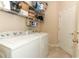 Laundry room with tile floors, shelving, and white washer and dryer at 4201 Old Trafford Way, Orlando, FL 32810