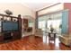 Bright living room with hardwood floors, entertainment center, and sliding glass doors to screened patio at 4201 Old Trafford Way, Orlando, FL 32810