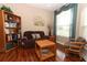 Cozy living room with hardwood floors, a comfortable sofa, bookshelf, and natural light at 4201 Old Trafford Way, Orlando, FL 32810