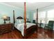 Bedroom with four-poster bed, hardwood floor, and large windows at 4201 Old Trafford Way, Orlando, FL 32810