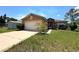 Charming single-story home with a two-car garage, well-maintained lawn, and inviting curb appeal at 440 Martigues Dr, Kissimmee, FL 34759