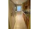 Efficient kitchen with tile flooring, wood cabinetry, laminate countertops and white refrigerator at 440 Martigues Dr, Kissimmee, FL 34759