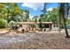 Expansive backyard with mature trees, a deck, and a barbecue grill, perfect for outdoor entertaining at 474 Overstreet Ave, Longwood, FL 32750