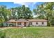 Charming single-story home with a well-manicured lawn and mature trees offering shade and curb appeal at 474 Overstreet Ave, Longwood, FL 32750