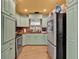 Well lit kitchen with light green cabinets, stainless steel appliances, and tile floors at 474 Overstreet Ave, Longwood, FL 32750