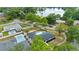 Aerial view of charming home with a pool, near a serene lake and surrounded by lush trees at 4804 Oakbrooke Pl, Orlando, FL 32812