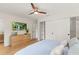 Bedroom with light wood floors, TV, and closet with shelves at 4804 Oakbrooke Pl, Orlando, FL 32812