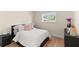 Cozy bedroom featuring wood floors, a comfy bed with pink pillows, and a bright window at 4804 Oakbrooke Pl, Orlando, FL 32812