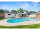Backyard pool area with covered patio, modern white home, and artificial turf at 4804 Oakbrooke Pl, Orlando, FL 32812