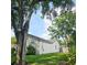 View of a lush backyard and tree, adjacent to home's white siding at 5005 Mill Stream Rd, Ocoee, FL 34761