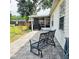 Paved patio with an iron bench, leading to a screened-in porch and a view of the spacious backyard at 5005 Mill Stream Rd, Ocoee, FL 34761