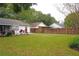 Spacious backyard featuring lush green grass, a wooden fence, and mature trees for privacy at 5005 Mill Stream Rd, Ocoee, FL 34761