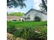 Front yard featuring lush greenery and a view of the home's architectural details at 5005 Mill Stream Rd, Ocoee, FL 34761