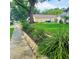 Side yard landscape with vibrant greenery, set on a street with sidewalk at 5005 Mill Stream Rd, Ocoee, FL 34761