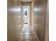 Hallway with tile flooring leads to a bathroom with a vanity and mirror at 5005 Mill Stream Rd, Ocoee, FL 34761