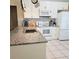 Well-lit kitchen showcasing granite countertops, stainless steel appliances, and tile flooring at 5005 Mill Stream Rd, Ocoee, FL 34761