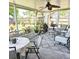 Relaxing screened porch furnished with comfortable seating, patterned rug, plants, and a ceiling fan at 5005 Mill Stream Rd, Ocoee, FL 34761