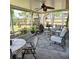 Relaxing screened porch furnished with comfortable seating, patterned rug, plants, and a ceiling fan at 5005 Mill Stream Rd, Ocoee, FL 34761