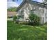 Landscaped side yard view with vibrant flowering bushes and lush green grass at 5005 Mill Stream Rd, Ocoee, FL 34761
