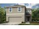 Charming two-story home with a two-car garage and neutral color palette, surrounded by lush landscaping at 5153 Forget Me Not Ave, Lake Hamilton, FL 33851
